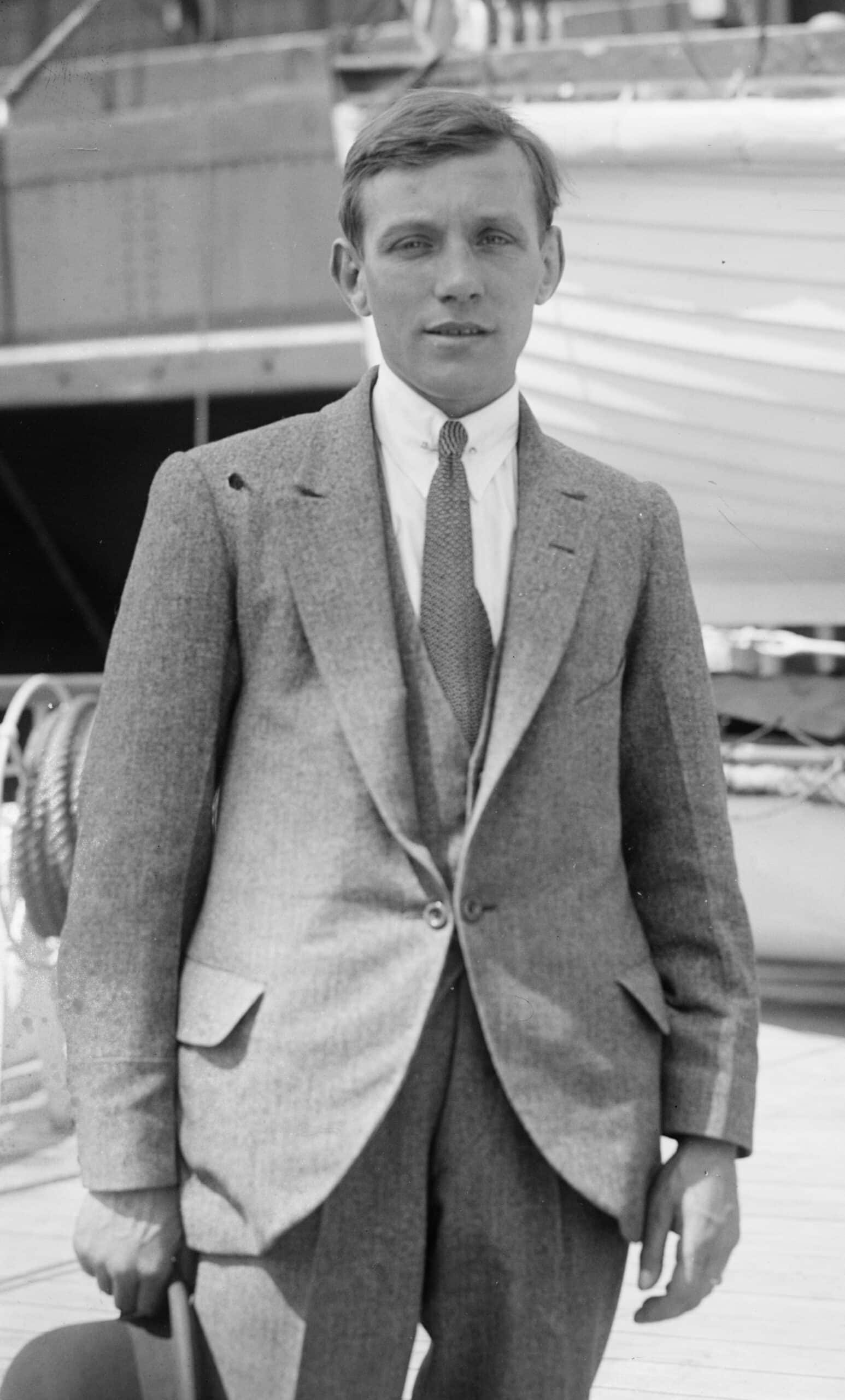 Black-and-white portrait of Welsh flyweight boxer Jimmy Wilde standing on the deck of a ship wearing a suit and tie, circa 1920.
